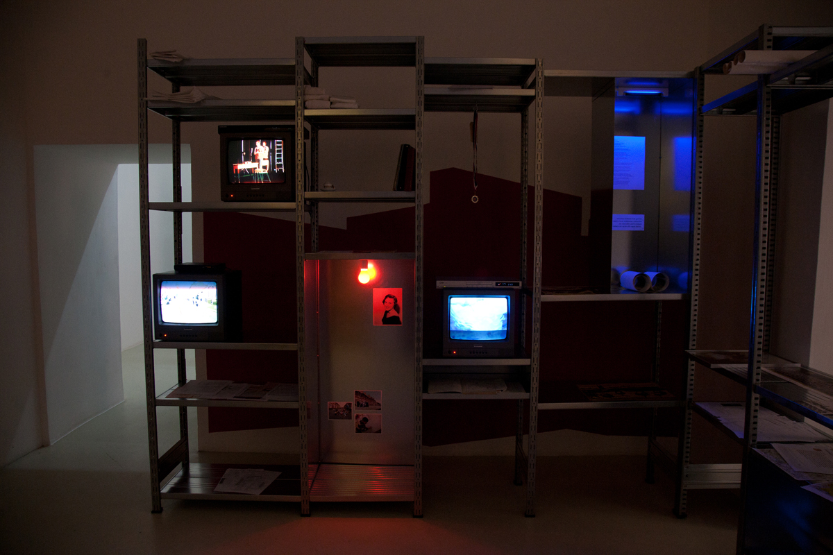 Rosas: The Trilogy, (Derby-The Attic), 2012, galvanized aluminum shelf, cctv monitors, photos, mixed media